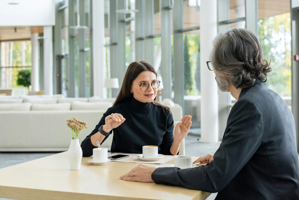 Gestor e colaboradora em conversa atenta durante reunião individual, representando o equilíbrio entre cuidado e franqueza ao dar feedback difícil