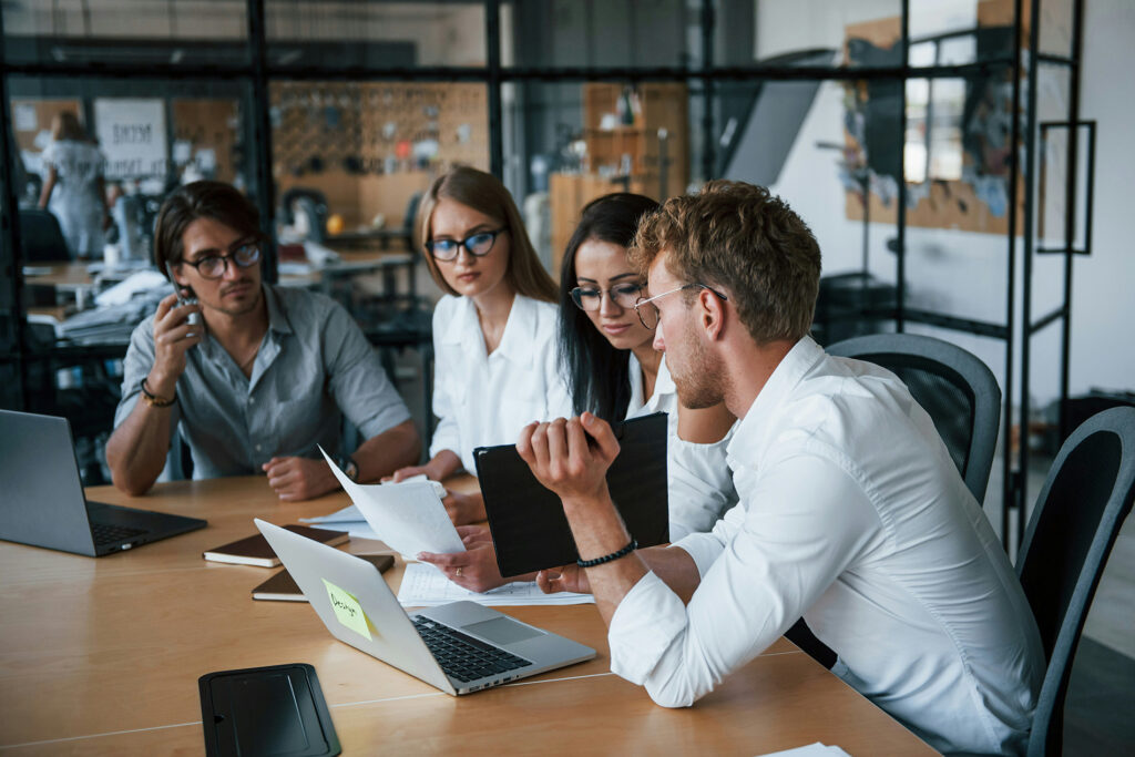 Equipe reunida analisando documentos e discutindo projeto em escritório, exemplo de liderança engajada com o time