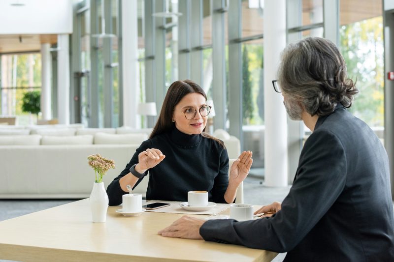Gestor e colaboradora em conversa atenta durante reunião individual, representando o equilíbrio entre cuidado e franqueza ao dar feedback difícil